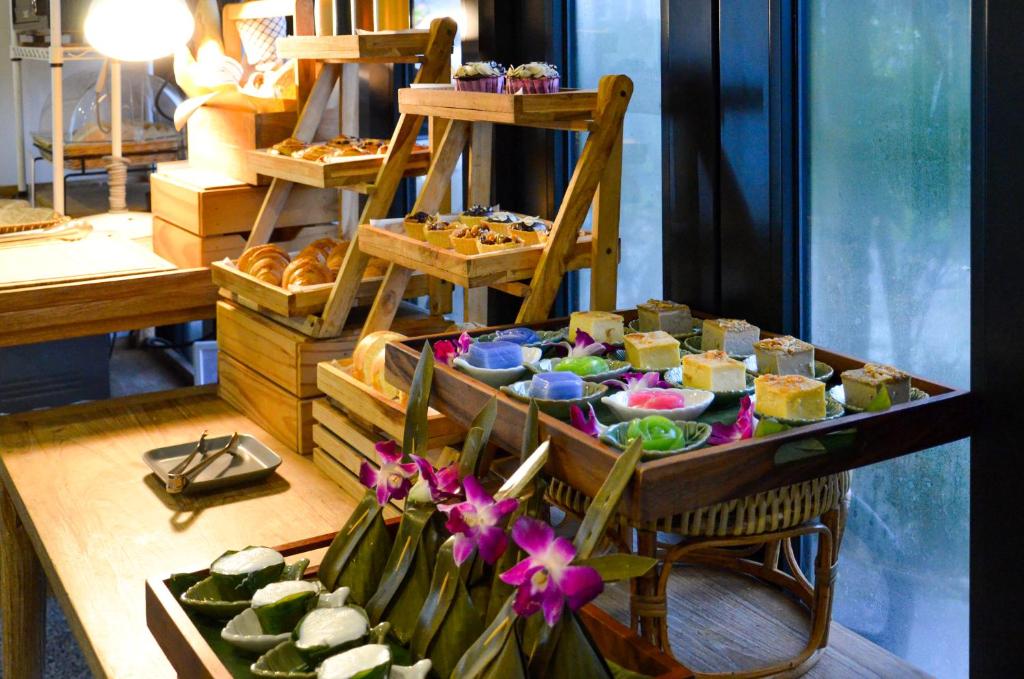 A decorative breakfast display features pastries, sweets and fruit arranged on wooden shelves.