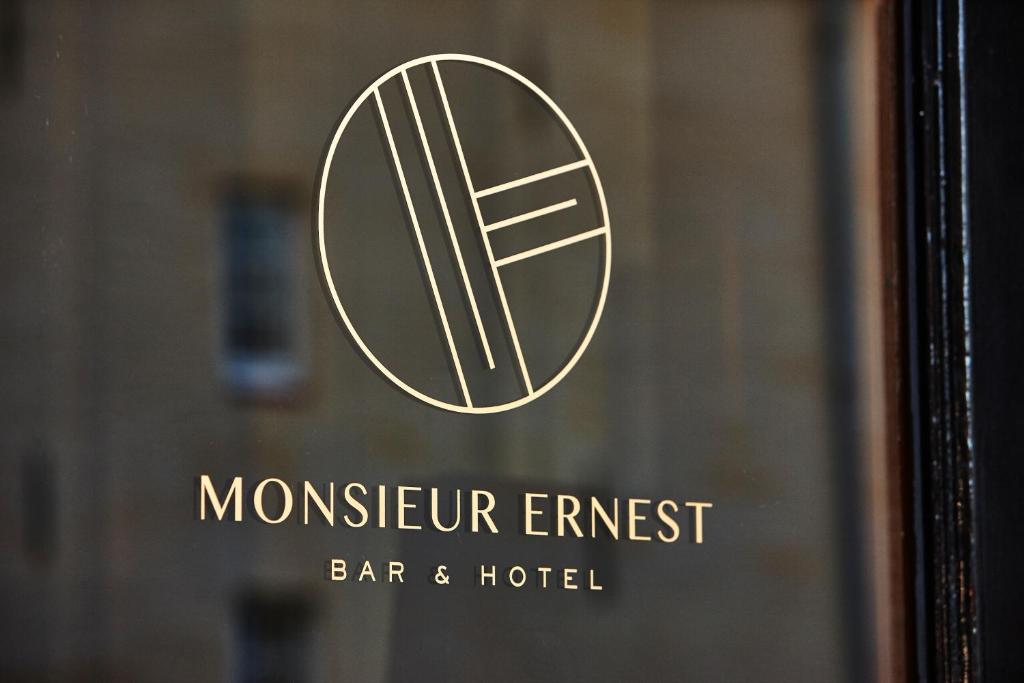 ein Schild für die Montecur Emigrant Bar und das Hotel in der Unterkunft Hotel Monsieur Ernest in Brügge