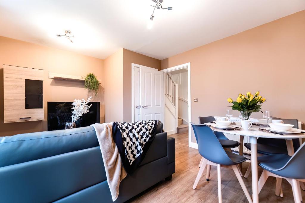a living room with a blue couch and a table at Black Brick Stays, Great Location, Free Parking, Fast Wi-Fi, Families & Contractors Welcome in Peterborough