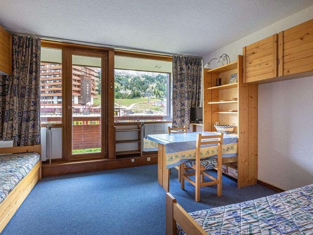 - une chambre avec un bureau, une table et une fenêtre dans l'établissement Studio confortable au pied des pistes à Plagne Centre avec balcon ensoleillé - FR-1-351-115, à Aime La Plagne