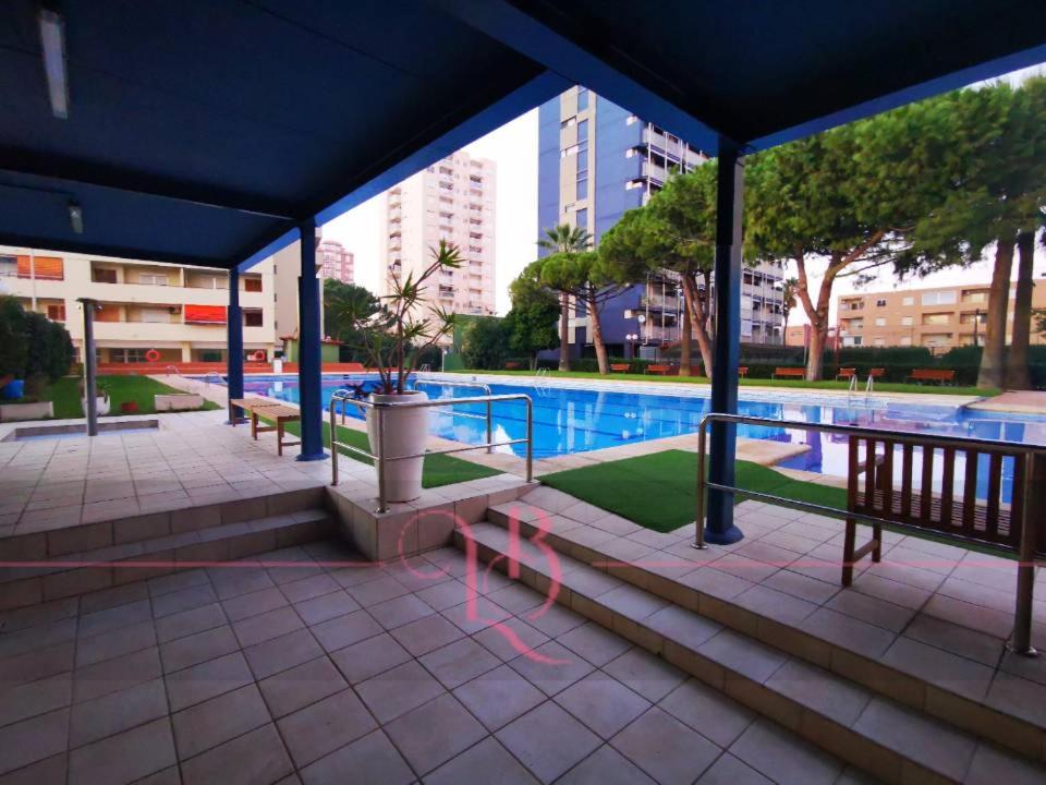 a pavilion with a pool in a city at Precioso apartamento residencial con vistas al mar in Puebla de Farnals