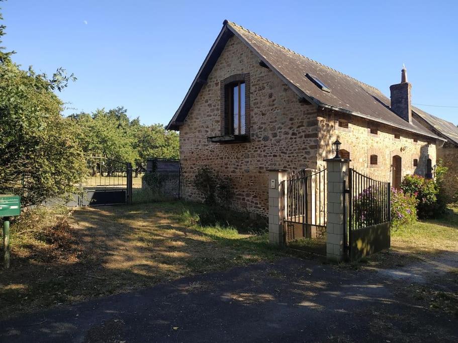 une vieille maison en briques avec une clôture devant elle dans l'établissement Petite maison à la campagne, à La Selle-Craonnaise
