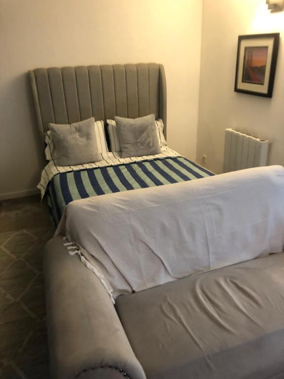 a bedroom with a large bed with blue and white sheets at Nw2 Studio Flat mins to London in London