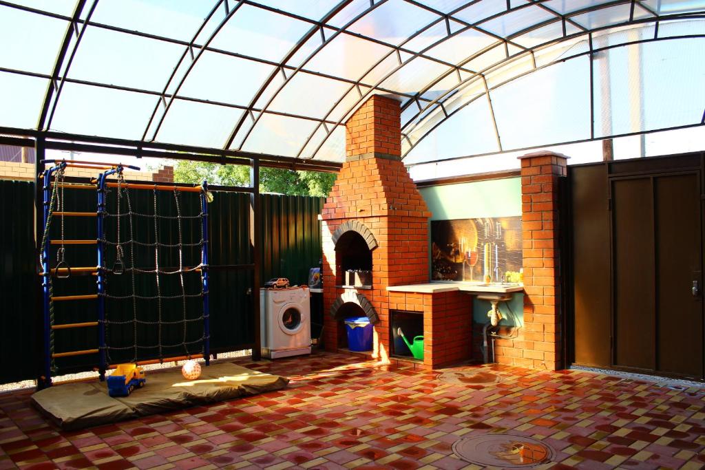 un patio con horno de ladrillo y techo de cristal en Holiday Home, en Yeysk