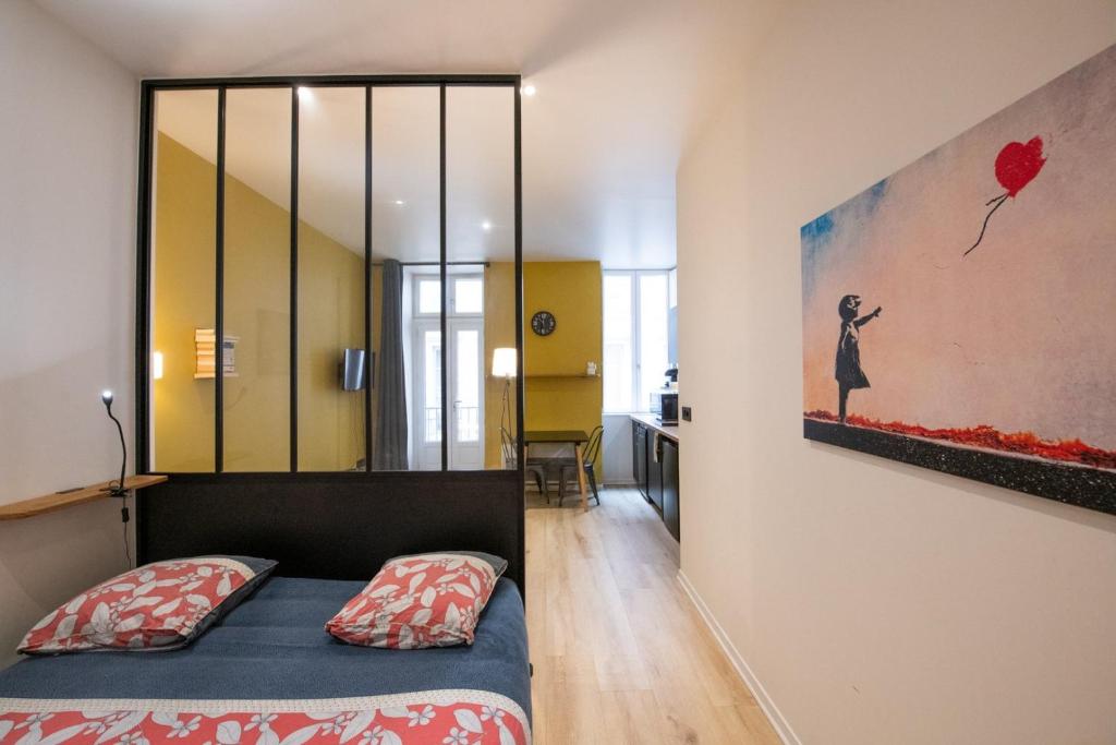 une chambre avec un lit et un tableau au mur dans l'établissement L'Opéra 10 - Beau studio avec balcon - Opéra, à Lyon