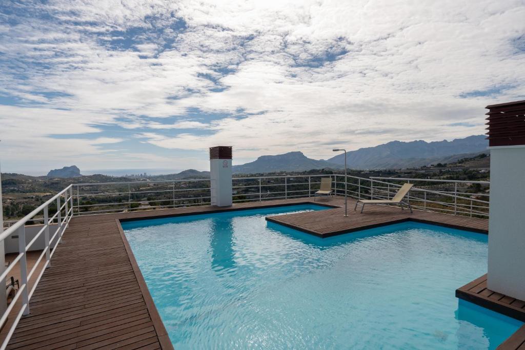 a swimming pool on the roof of a building with mountains at Casa2Iberia in Benissa