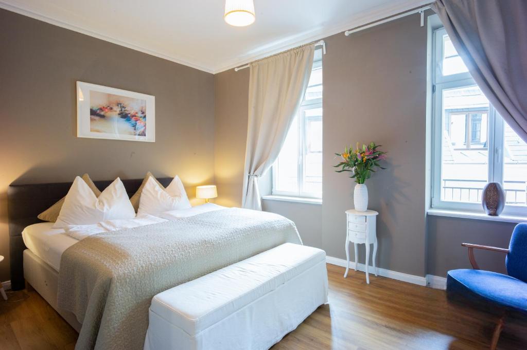a bedroom with a large bed and a blue chair at Marktblick Apartments nähe der RB-Arena in Leipzig