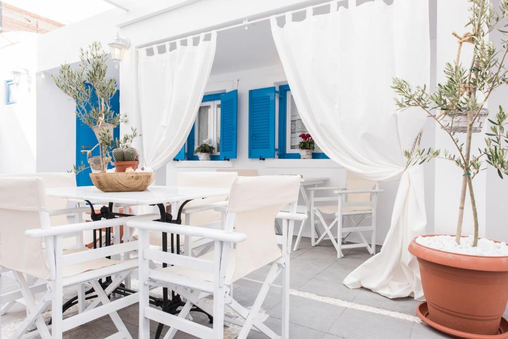 フィラにあるIokasti Villaの白い椅子と植物のテーブルが備わる白い部屋