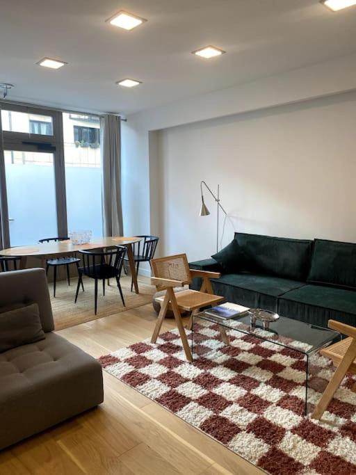 un salon avec un canapé vert et une table dans l'établissement Modern parisian flat in Montparnasse area, à Paris