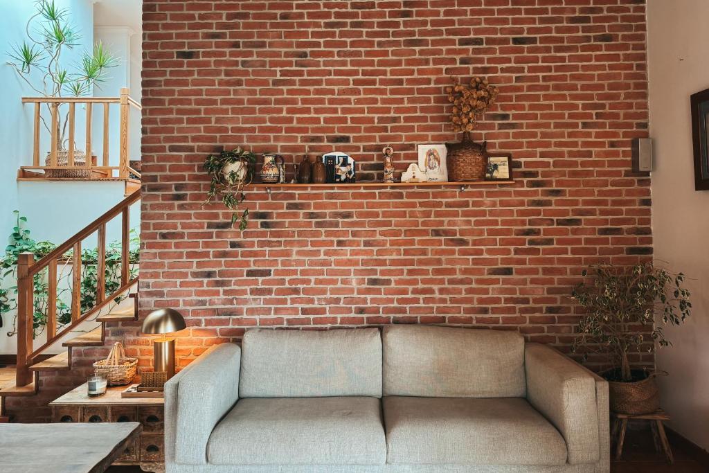 a living room with a couch against a brick wall at Quinta Amarela - B&B in Nazaré