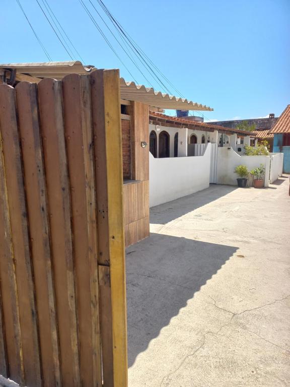 a wooden fence in front of a house at Vilmar suítes in Maricá