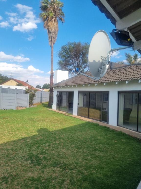 a house with a large yard with a satellite at Jazreel b&b in Vanderbijlpark