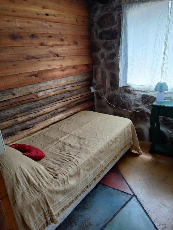a bed in a room with a wooden wall at Habitaciones individuales o Dobles en La Llave in San Javier