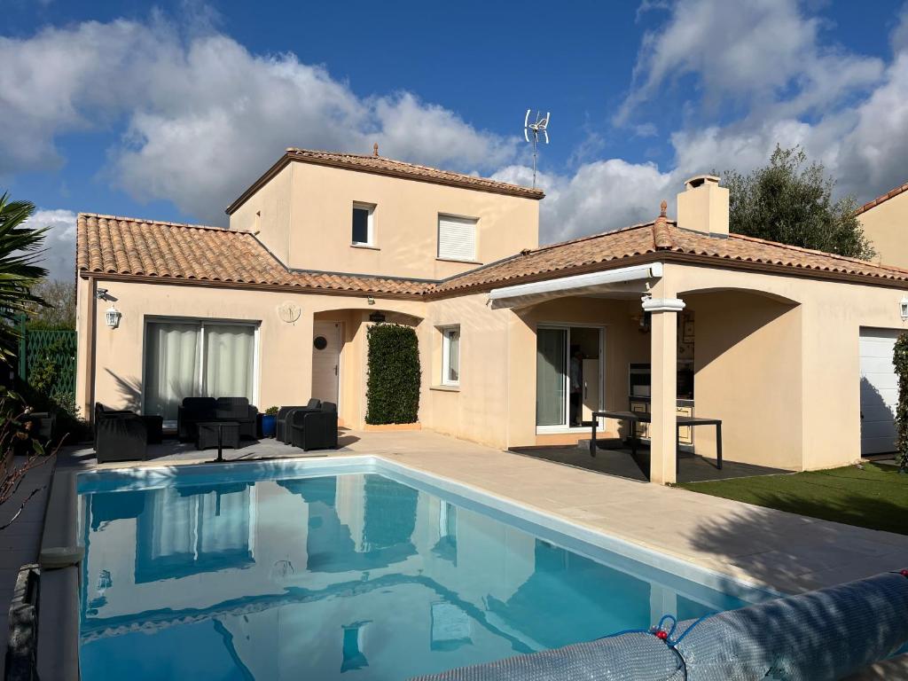 una villa con piscina frente a una casa en Les hortensias, en Les Sables-dʼOlonne