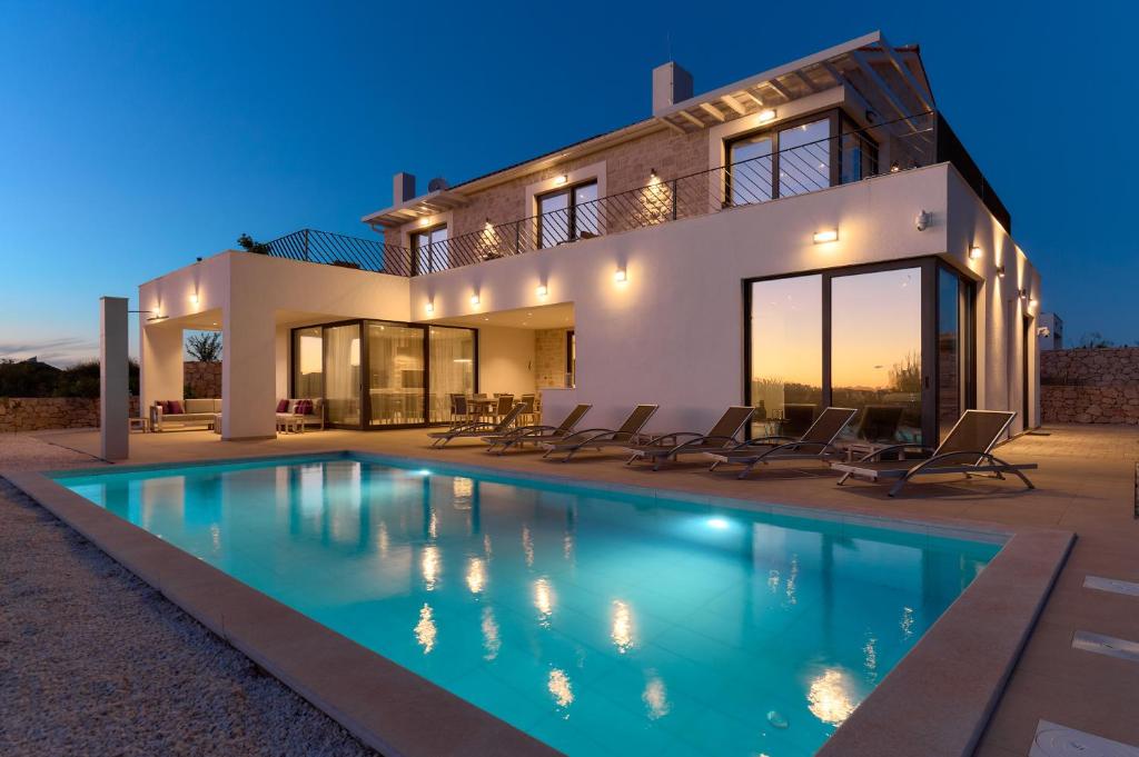 a villa with a swimming pool in front of a house at Villa Liliana Vodice in Vodice