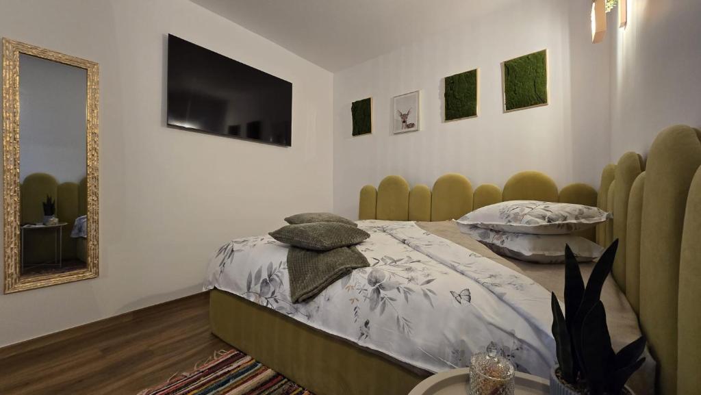 a bedroom with a bed and a television on the wall at For You Apartments Silence in Sibiu