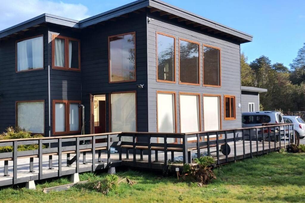 una casa negra con un gran porche delantero en Hermosa casa en parcela, en Puerto Varas