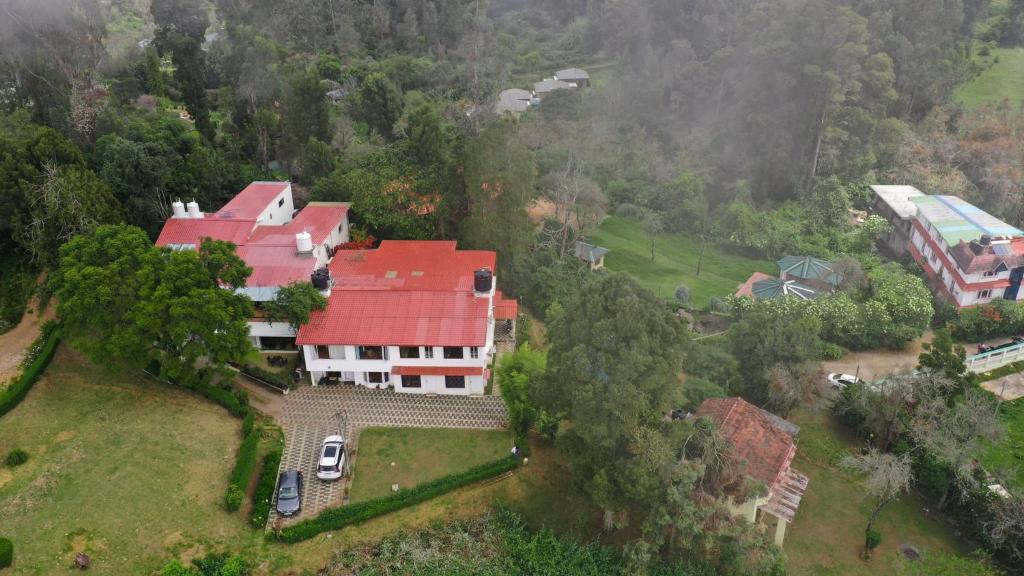 an aerial view of a large house with a red roof at HappyHuts at Green valley view in Kodaikānāl