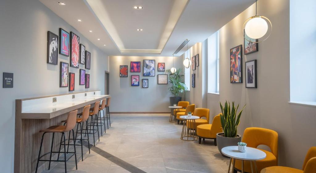 a bar with chairs and tables in a restaurant at Maldron Hotel Brighton City Centre in Brighton & Hove