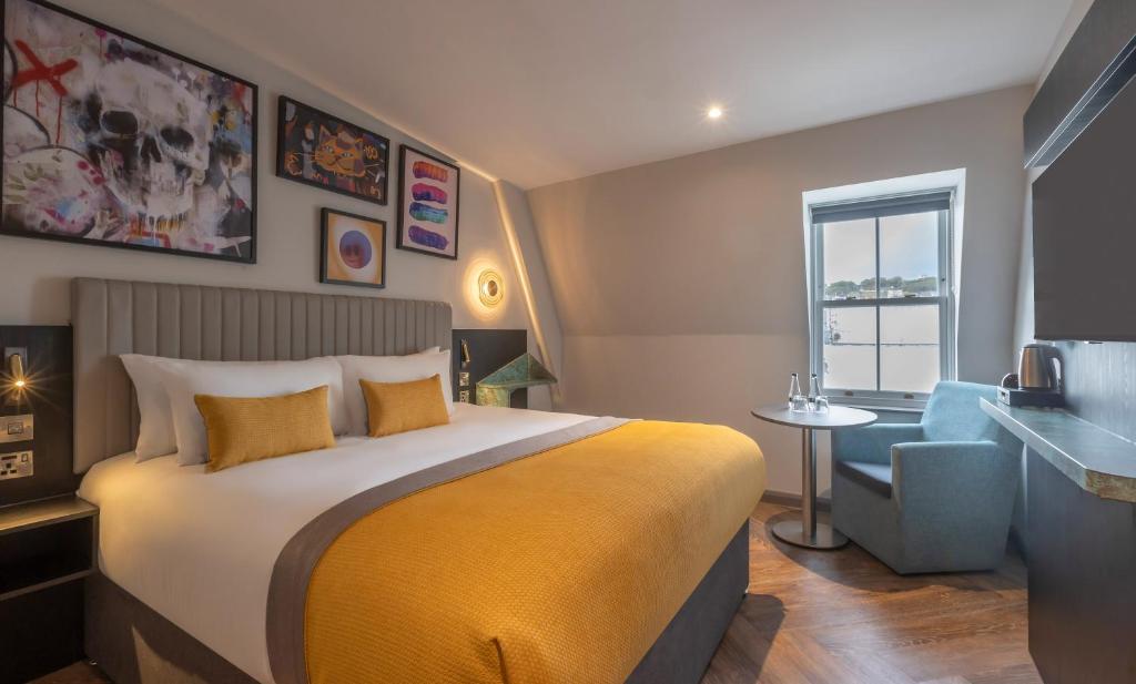 a hotel room with a bed and a chair at Maldron Hotel Brighton City Centre in Brighton & Hove
