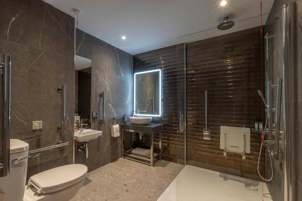 a bathroom with a toilet and a sink and a shower at Maldron Hotel Brighton City Centre in Brighton & Hove