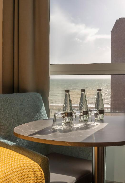 a table with four glasses on it with a window at Maldron Hotel Brighton City Centre in Brighton & Hove