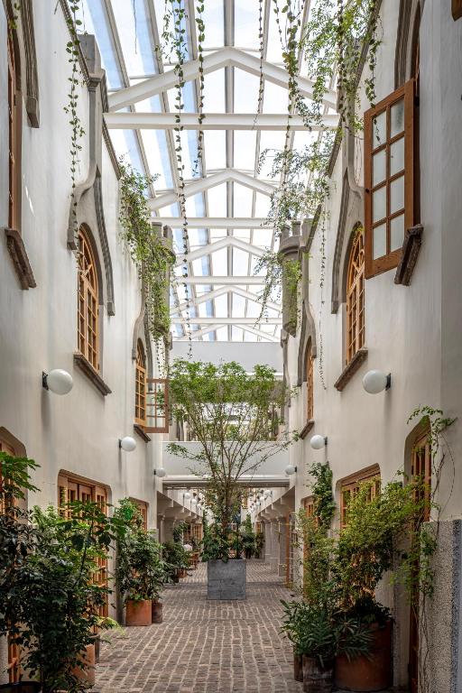 an empty hallway with plants and a glass ceiling at Hotel Parián in Mexico City