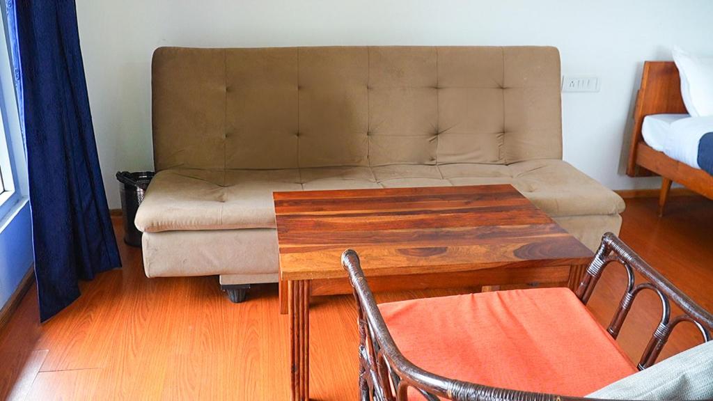 a living room with a couch and a coffee table at HappyHuts at Green valley view in Kodaikānāl