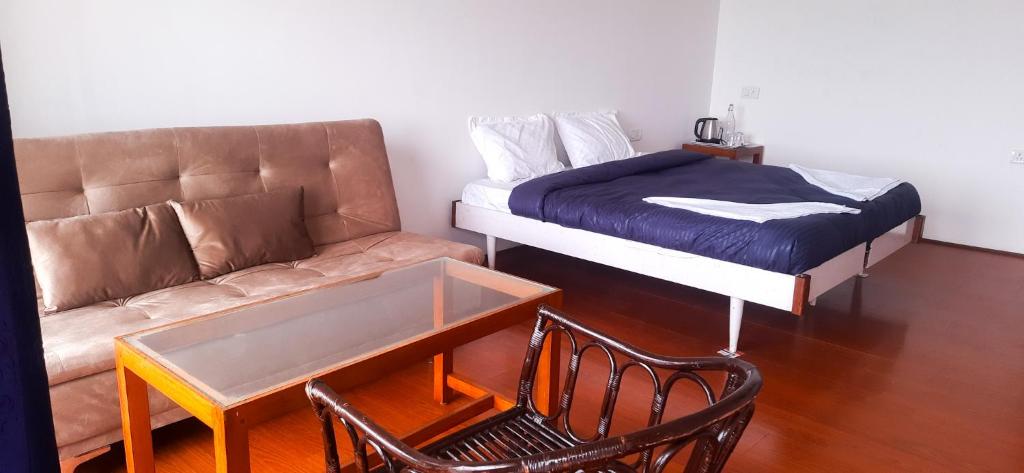 a living room with a couch and a bed at HappyHuts at Green valley view in Kodaikānāl