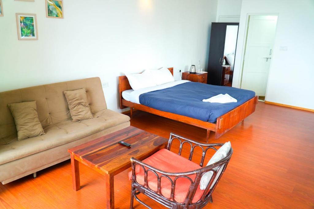 a living room with a bed and a couch at HappyHuts at Green valley view in Kodaikānāl