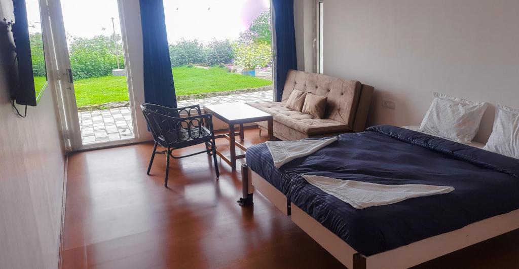 a bedroom with a bed and a chair and a table at HappyHuts at Green valley view in Kodaikānāl