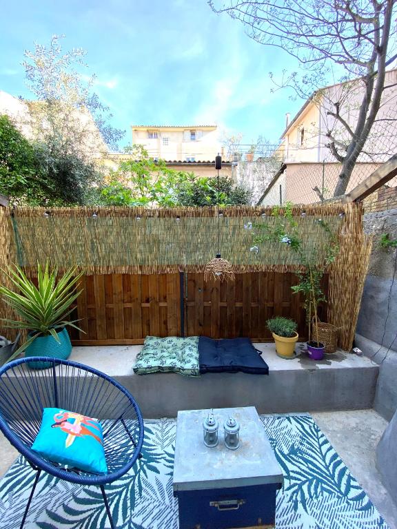 un patio avec une table et des chaises et une clôture dans l'établissement Le Petit Vendôme avec terrasse, à Aix-en-Provence