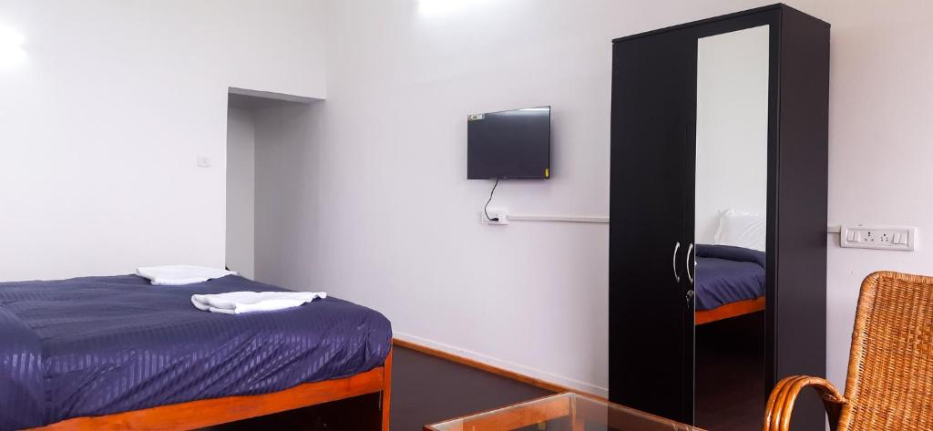 a small bedroom with a bed and a mirror at HappyHuts at Green valley view in Kodaikānāl