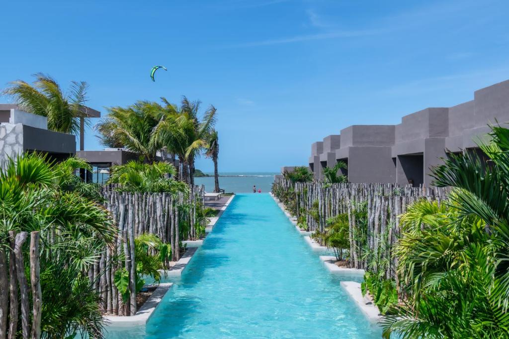 a long resort pathway with palm trees on the beach at Koloa Concept Hotel in Barra Grande