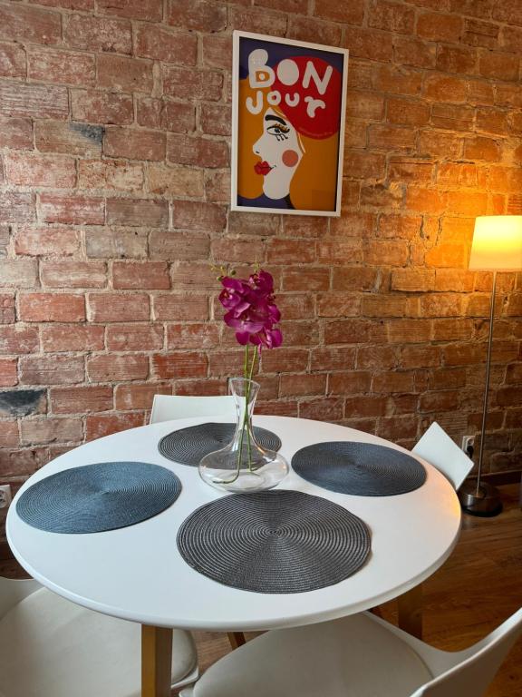 una mesa blanca con un jarrón de flores en la parte superior en Apartament Akali Centrum 300 m Rynek 1-4 os -Parking, en Kielce