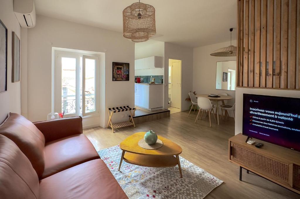 a living room with a couch and a table at Les Toits de la Canebière - Studio tout confort in Marseille