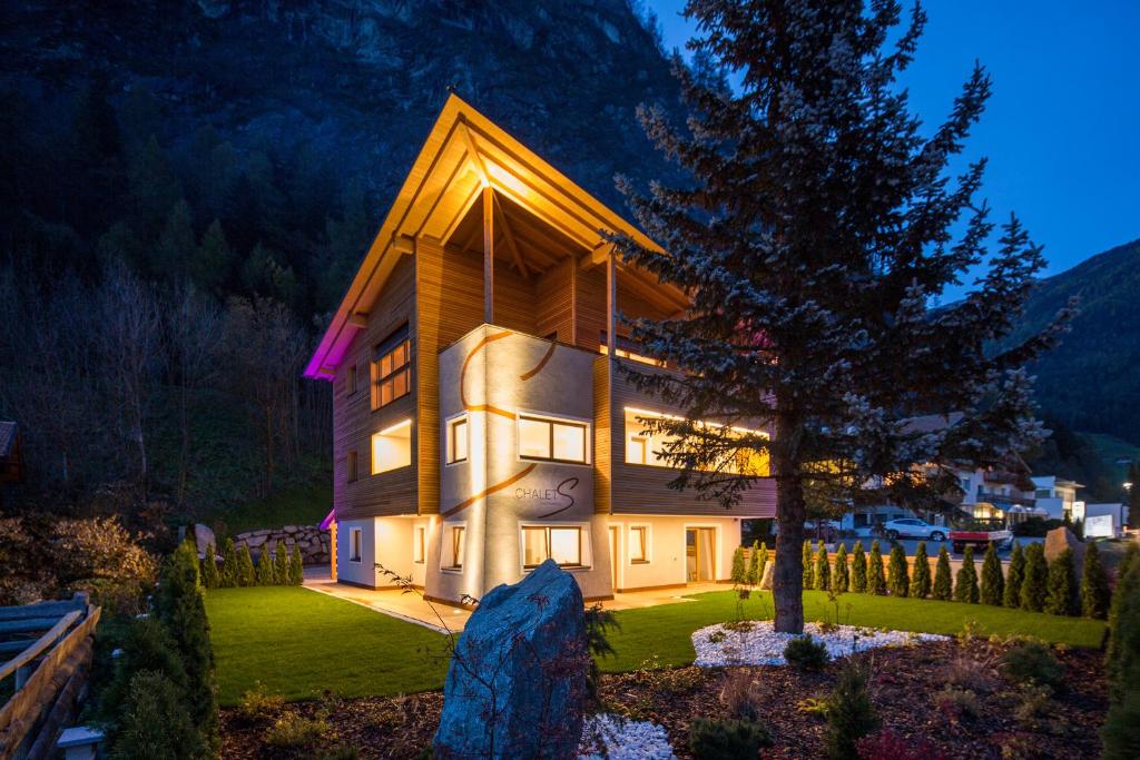 a large house with a tree in front of it at Chalet S Apartments in Campo Tures