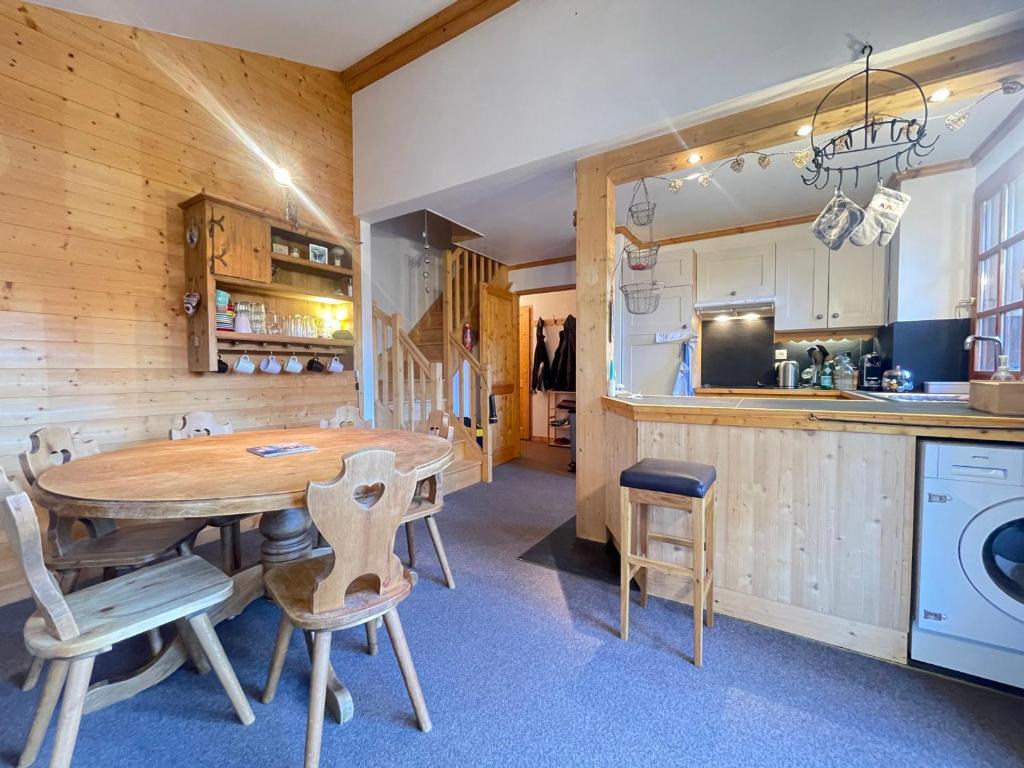 a kitchen and dining room with a wooden table and chairs at Duplex de Charme pour 6 Personnes, Proche Centre et Pistes de Ski - FR-1-505-209 in Notre-Dame-de-Bellecombe