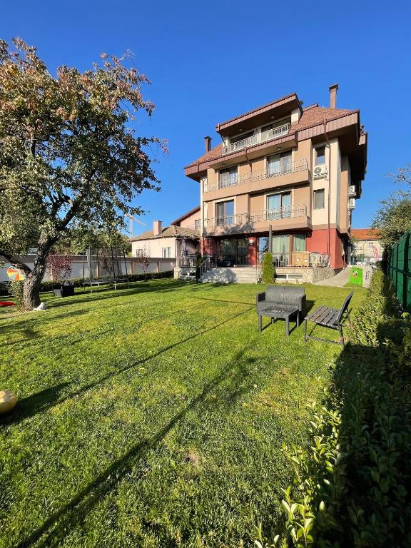 a park with a bench in front of a building at ZaraApartHotel in Sofia