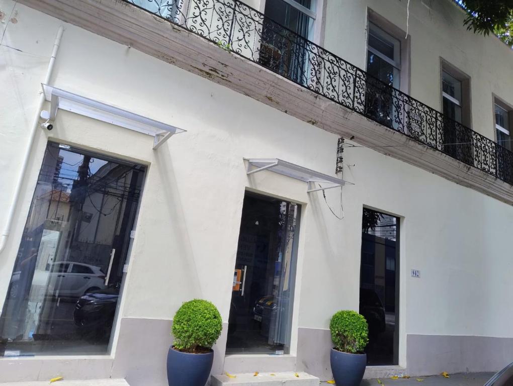 a white building with two plants in front of it at ABA Hotel in Belém