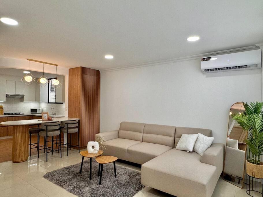 a living room with a couch and a kitchen at Departamento acogedor y moderno in SamborondÃ³n