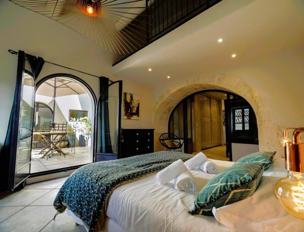 a bedroom with a bed in a room with a balcony at Appartement d'Exception Terrasse Ensoleillée in Saint-Rémy-de-Provence