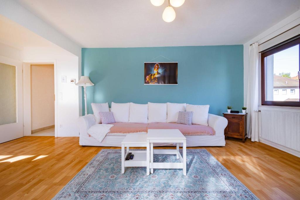 a living room with a white couch and a table at Charmante Wohnung -Altes Kino- 2SZ-2Bad-Terrasse-Netflix in Baden-Baden
