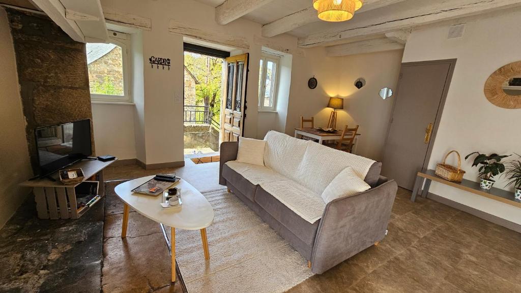 a living room with a couch and a table at Maison la Doucette et son extérieur in Salles-la-Source