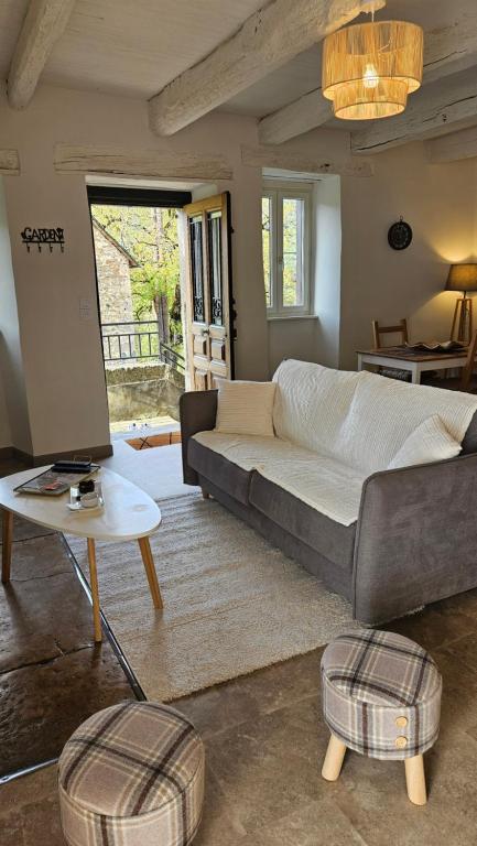 a living room with a couch and a table at Gîte la Doucette proche des Cascades in Salles-la-Source