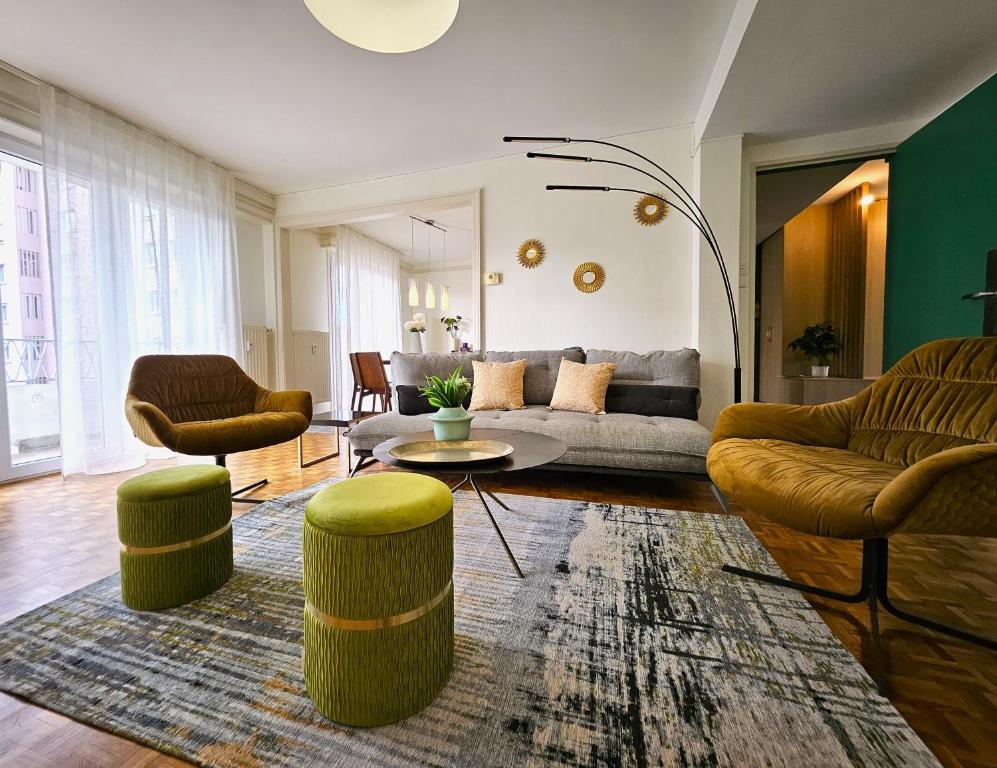 un salon avec un canapé, deux chaises et une table dans l'établissement Charmant T4- Centre Ville- Parking Privé, à Colmar