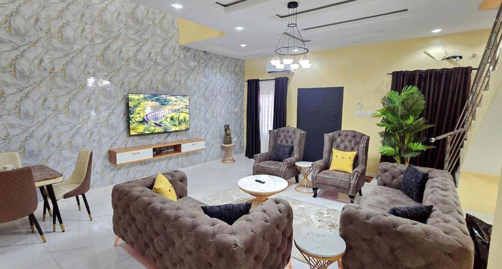 a living room with a couch and chairs and a table at Eden Luxurious Apartments in Mosere Ikoga