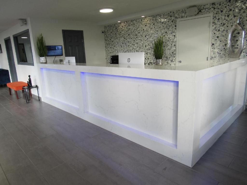 um lobby com um balcão branco com luzes azuis em Hotel 10 Extended Stay em Nova Orleães