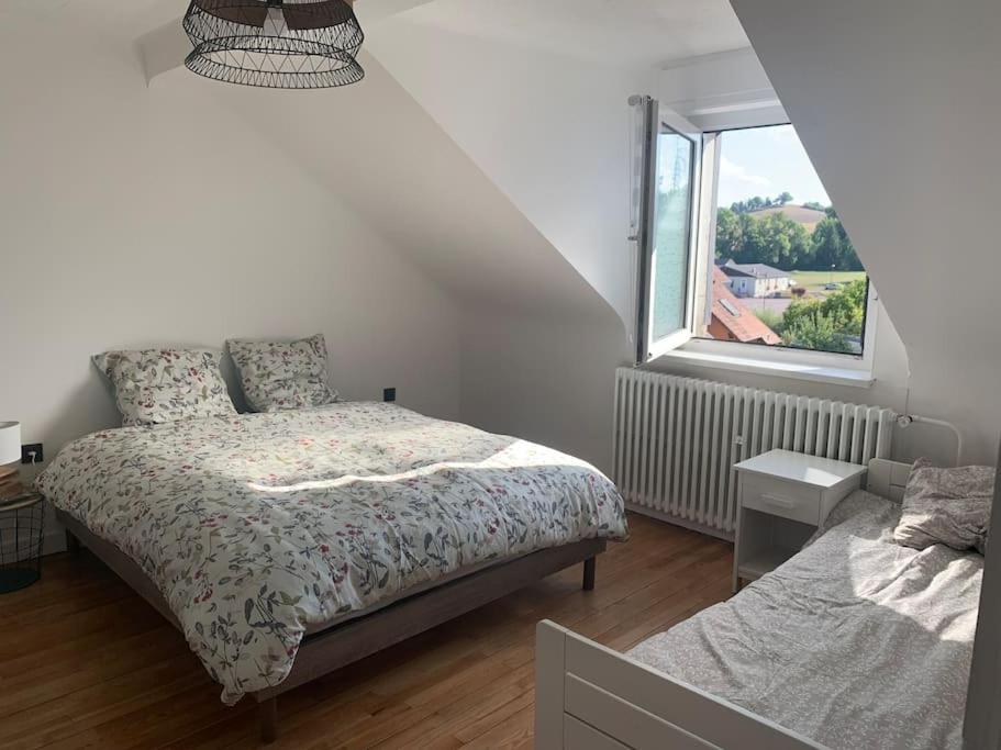 a bedroom with a bed and a window at Ch'tite Maison, Bienvenus à Vous! in Altrippe
