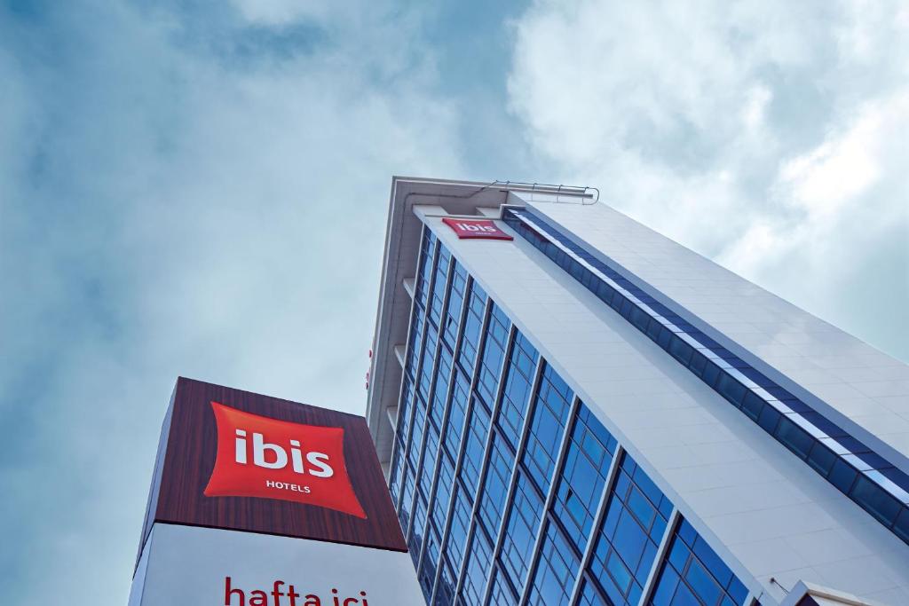 a building with aubs sign on the side of it at Ibis Konya in Konya